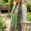 Woman wearing Thea Porter Lebanon silk scarf in sheer green chiffon styled in a garden setting