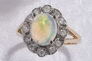 The Heritage Collection: Large, lustrous opal set in a diamond and 18ct gold cluster ring