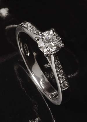 Solitaire diamond ring with two lines of shoulder diamonds