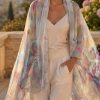 Woman wearing the Jardin de Lune oversized pure silk chiffon stole with painterly floral print in oyster grey, fuchsia and Riviera blues