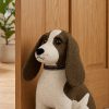 Dora Designs Springer Spaniel doorstop holding open a wooden door