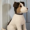 Dora Designs Jack Russell dog doorstop beside a painted wooden door