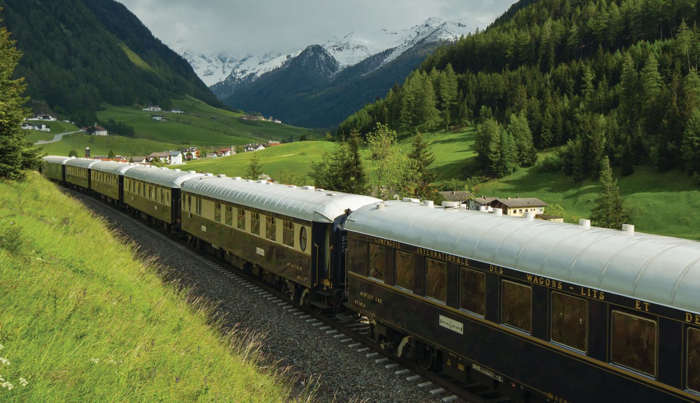 Venice Simplon-Orient-Express luxury train travelling through spectacular spring Alpine scenery on the classic Paris to Venice route over the Alps