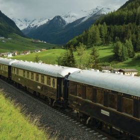 Venice Simplon-Orient-Express luxury train travelling through spectacular spring Alpine scenery on the classic Paris to Venice route over the Alps