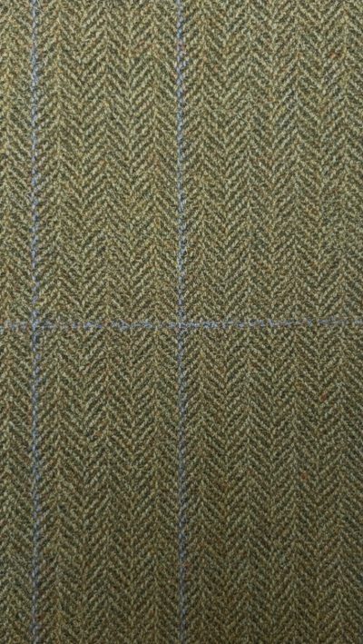 Close-up of Gurteen Blenheim pure wool tweed fabric – green herringbone weave with fine orange overcheck