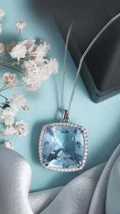large cushion cut Ceylon aquamarine pendant surrounded by diamond halo in platinum