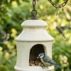 Ceramic hanging bird feeder with blue tit feeding on seed