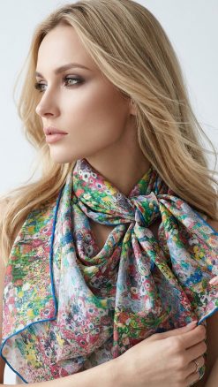 Blonde model wearing Fox & Chave Klimt Dancer silk chiffon scarf tied at neck, vibrant painterly floral pattern in rich reds, greens, blues and yellows, elegant close-up