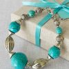 Aleyne Earth & Sky Bracelet turquoise beads stainless steel on fabric background