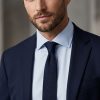 Man wearing black knitted silk tie with navy suit and light blue shirt.