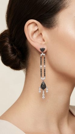 Woman wearing Effy Art Deco black and white diamond drop earrings