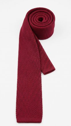 Close-up of pure silk red wine knitted tie showing textured ribbed knit and square-end detail