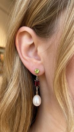 Seraphine pearl earrings in 14ct gold with peridot, garnet and pearl worn on model