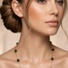 Woman wearing Shadow Flame black onyx beaded station necklace 14K gold