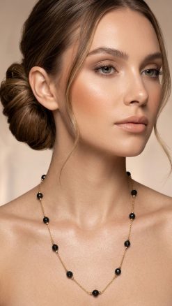Woman wearing black onyx beaded station necklace 14K gold