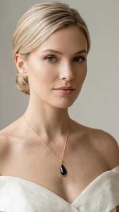 Woman wearing faceted black onyx pendant necklace 14K gold