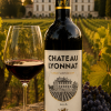 Chateau Lyonnat Lussac Saint-Emilion bottle in front of Chateau Lyonnat